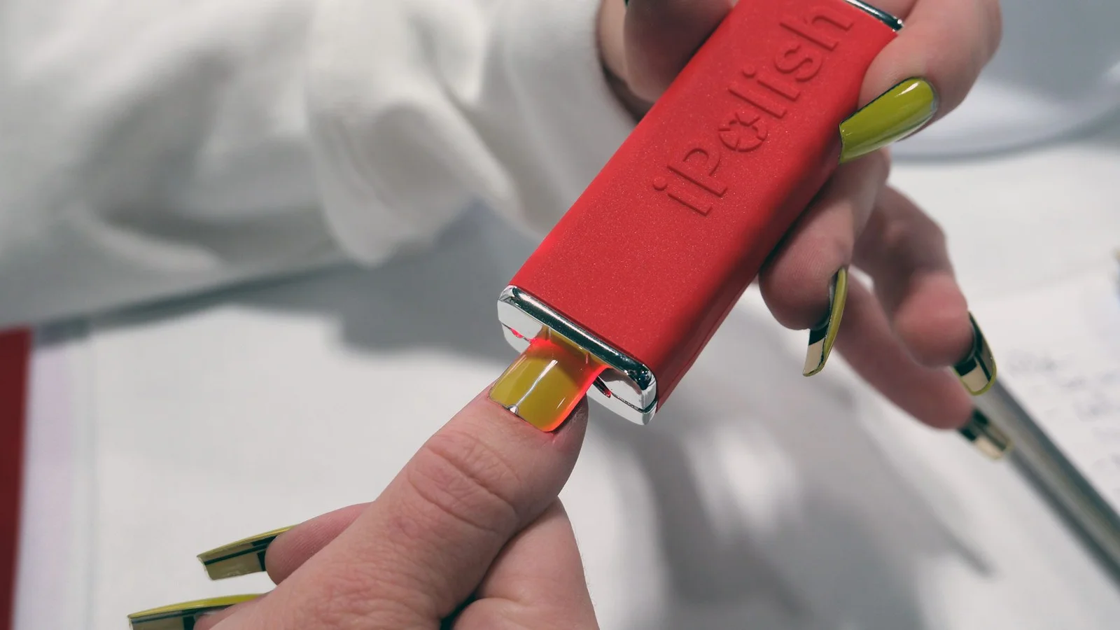 Dispositivo iPolis utilizado sobre una uña durante un tratamiento de manicura profesional con tecnología para uñas inteligentes.