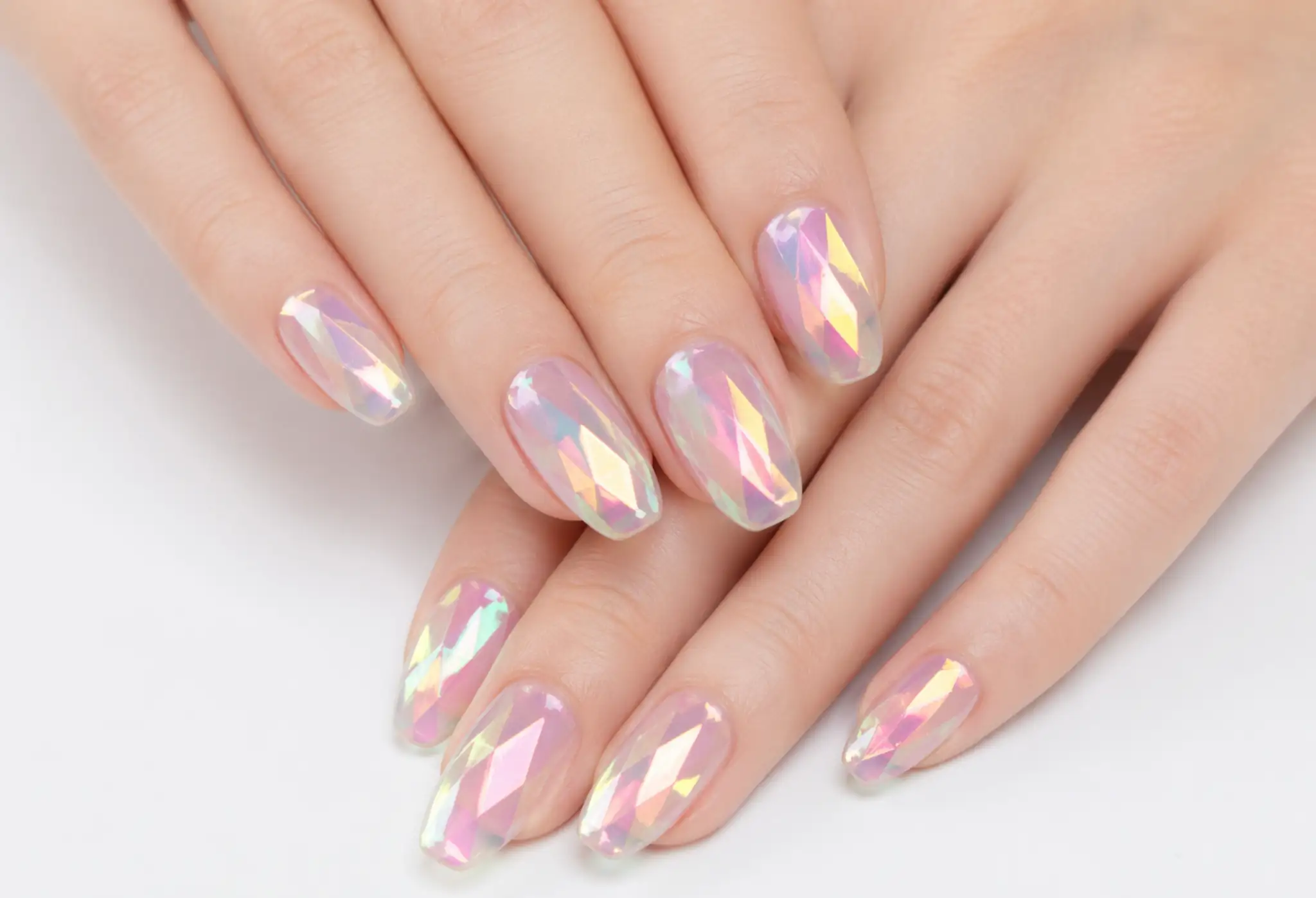 Manos con manicura glass nails efecto cristal con acabado brillante y reflejos holográficos