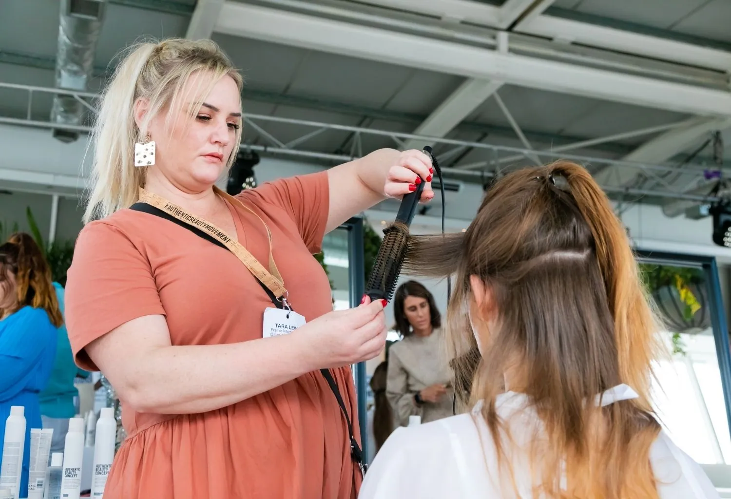 Profesional de peluquería realizando formación técnica con herramientas de styling en salón