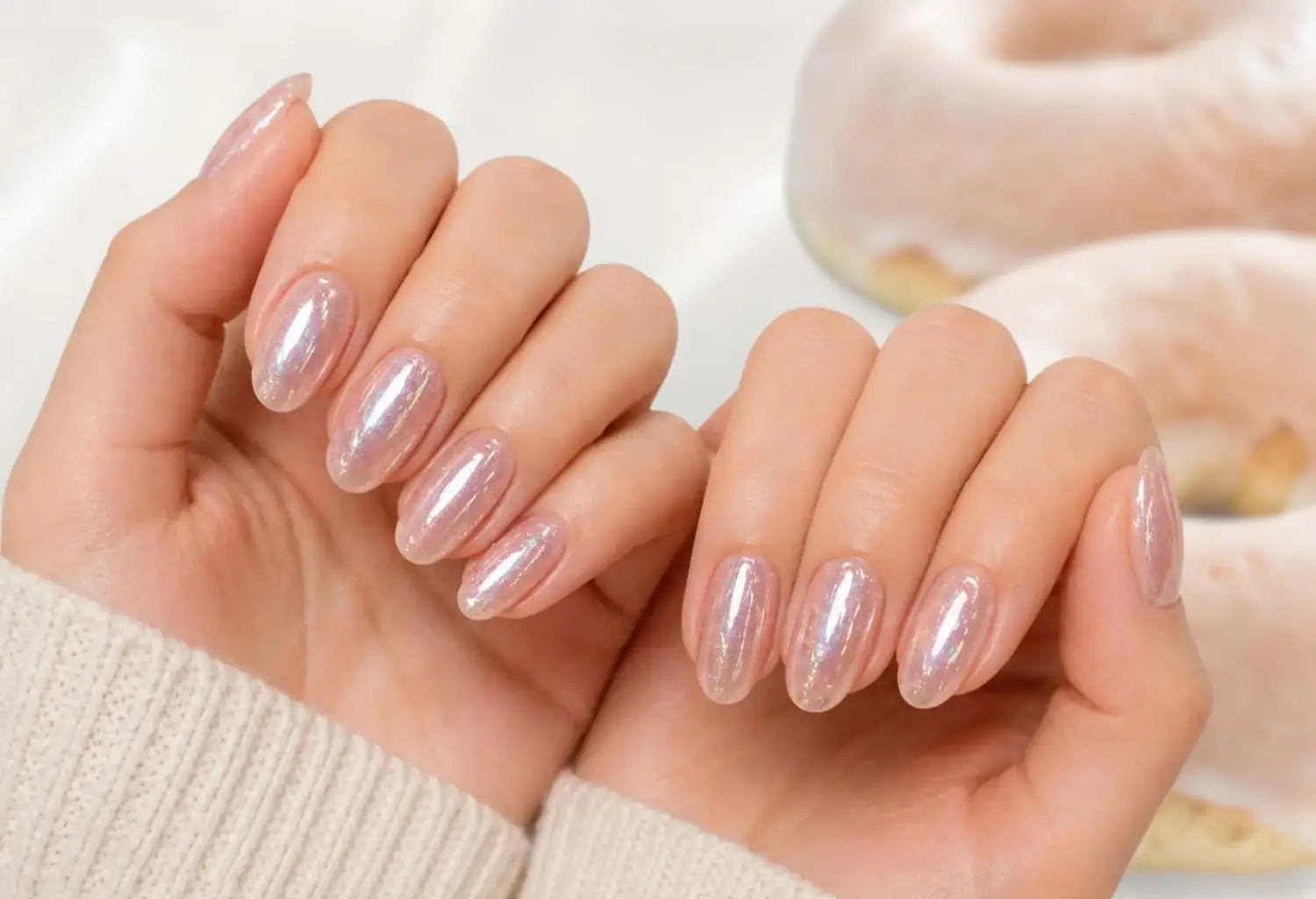Manos con manicura glazed donut nails con acabado brillante perlado y efecto espejo suave