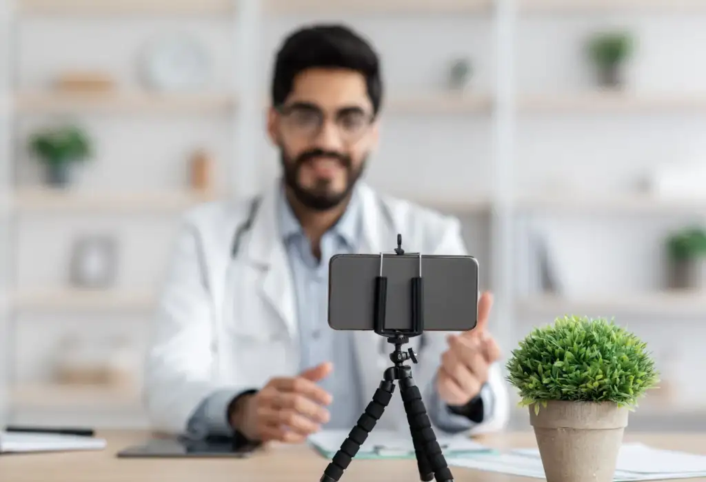 Dermatólogo grabando un vídeo sobre cuidado de la piel con el móvil para redes sociales