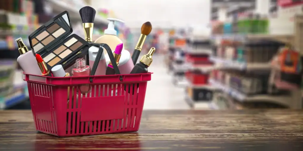 Cesta de compra con productos de maquillaje y cosmética en un supermercado beauty