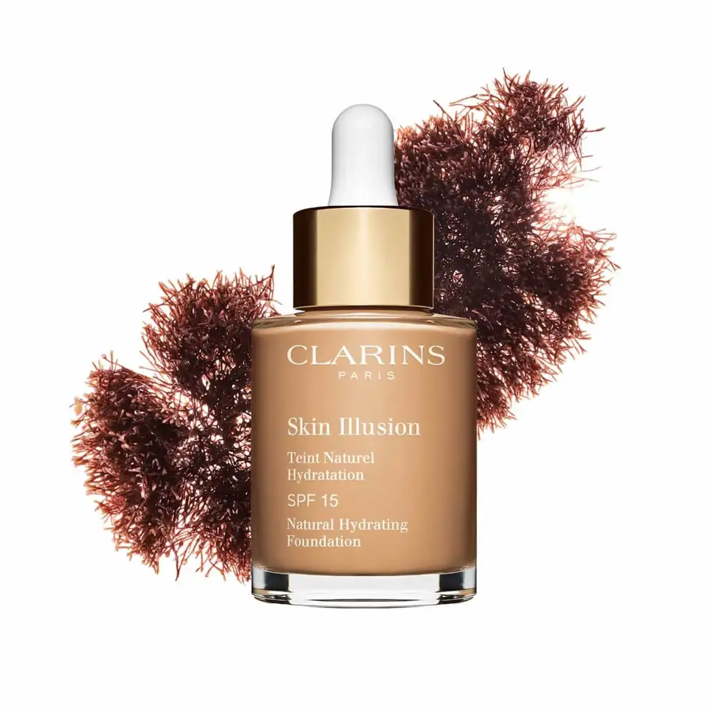Clarins Skin Illusion SPF 15 base de maquillaje hidratante Base de maquillaje Clarins Skin Illusion SPF 15 con acabado natural e hidratante presentada junto a ingredientes botánicos.