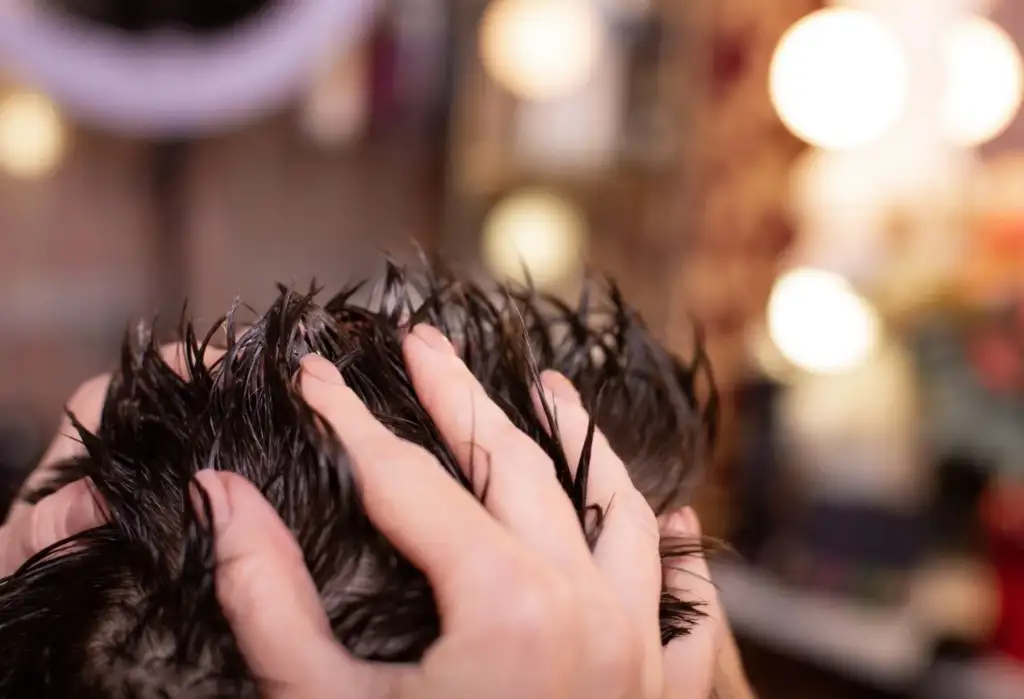 Masaje manual sobre el cuero cabelludo durante un tratamiento capilar para estimular la circulación y mejorar la salud del cabello.
