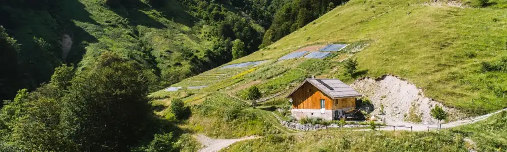 Casa de madera rodeada de montañas y campos verdes en el Domaine Clarins.