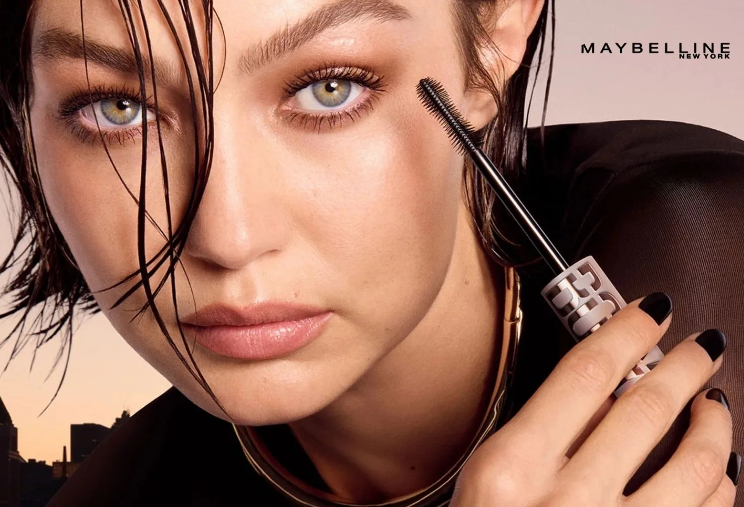 Modelo aplicando máscara de pestañas Maybelline con efecto lifting para lograr más volumen, longitud y definición.