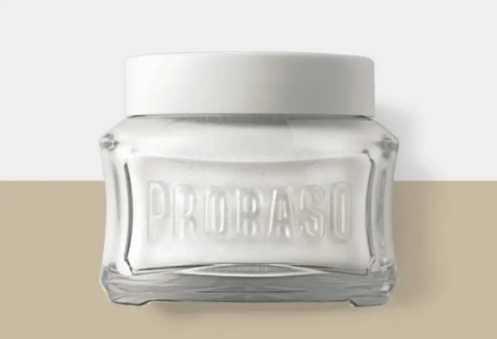 Tarro de crema de afeitar Proraso con diseño minimalista sobre fondo neutro beige y gris.