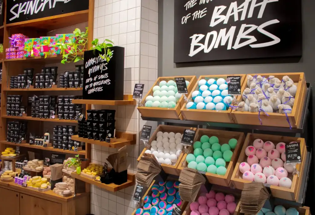 Expositor con bombas de baño de colores en una tienda de cosmética y cuidado corporal.