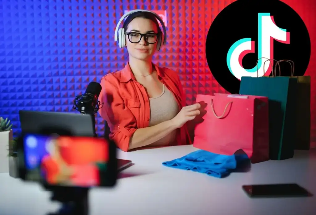 Creadora de contenido realizando una retransmisión de live shopping en TikTok con productos y bolsas de compra.