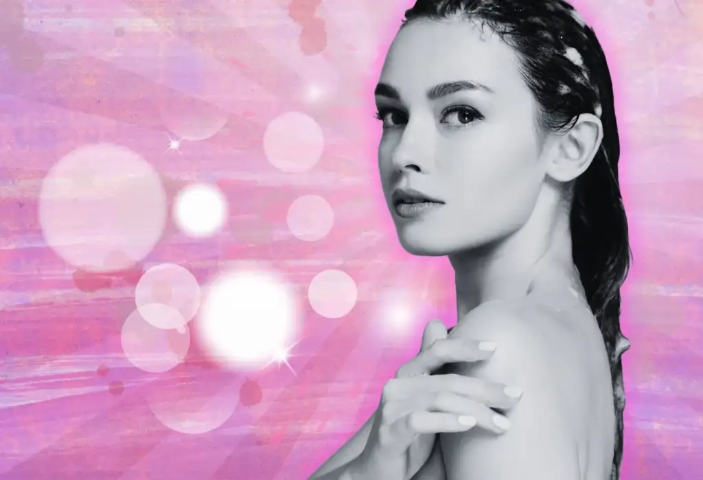 Tratamiento capilar hidratante con efecto brillo intenso Mujer con cabello húmedo y tratamiento capilar sobre fondo rosa luminoso y artístico.