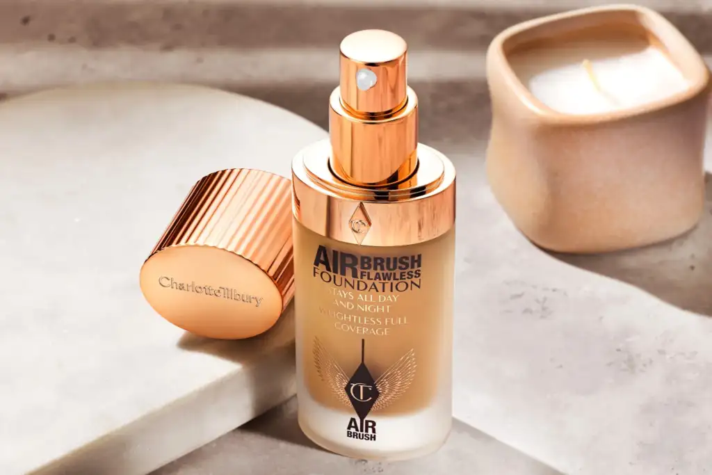 Botella de Charlotte Tilbury Airbrush Flawless Foundation sobre una superficie de piedra, mostrando el envase de lujo de esta base de maquillaje de larga duración.