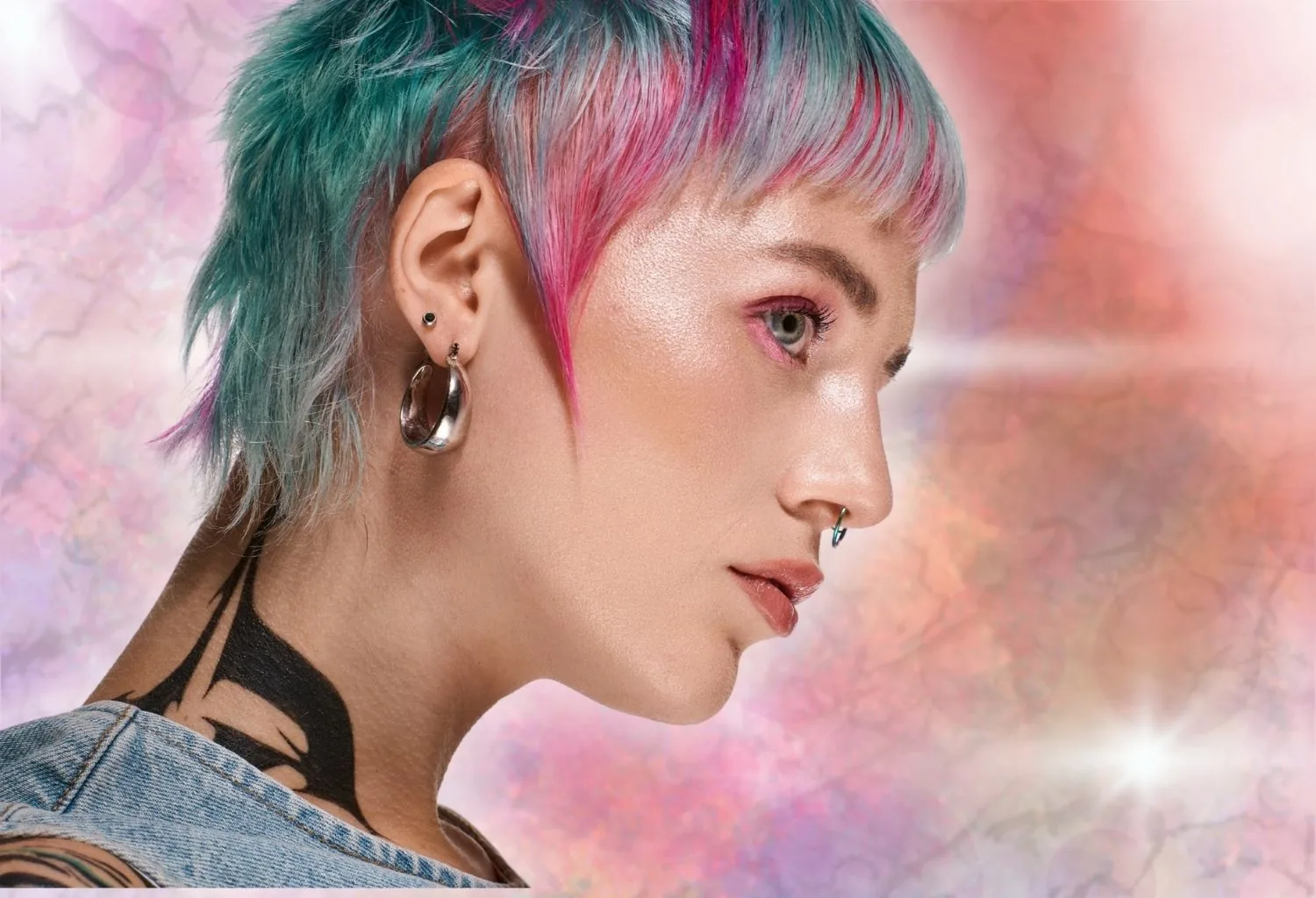 Modelo con corte corto y coloración artística en tonos rosa, azul y plata realizada con técnicas profesionales de color personalizado.