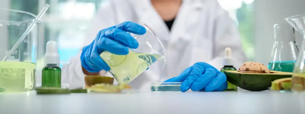 Investigador formulando cosmética natural con ingredientes botánicos en un laboratorio de desarrollo cosmético
