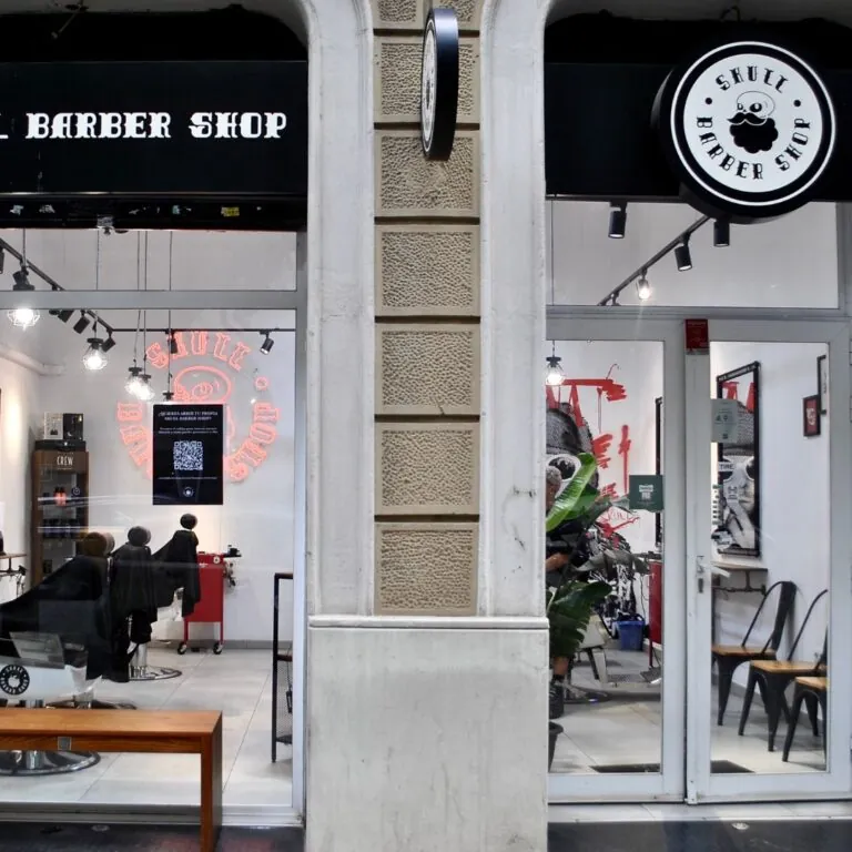 Fachada de una barbería moderna con escaparate acristalado y diseño profesional en zona urbana.