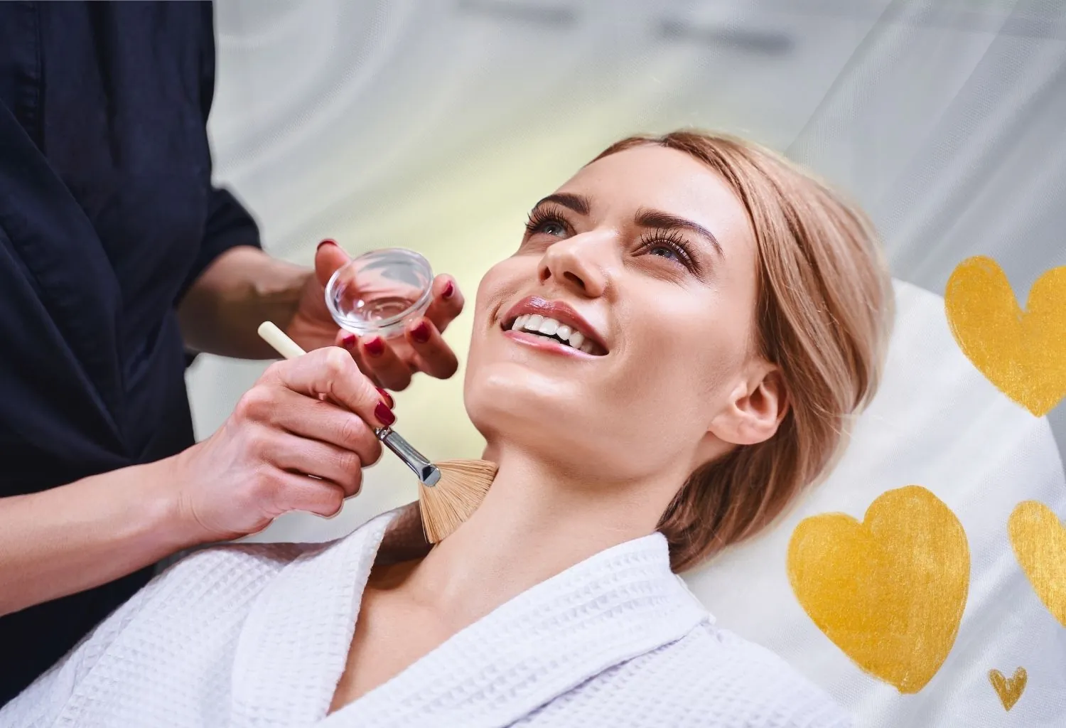 Mujer recibiendo un tratamiento facial estético con brocha cosmética durante una sesión de cuidado preventivo de la piel.