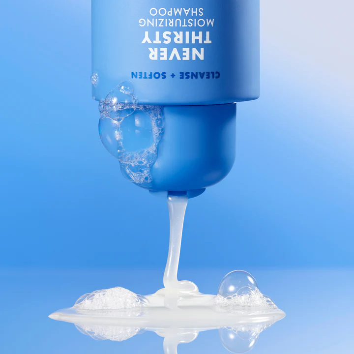 Champú hidratante Never Thirsty de e.l.f. con espuma y textura cremosa sobre fondo azul.