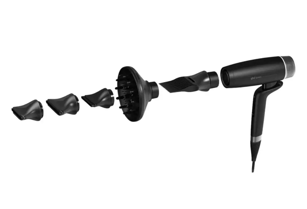 Secador profesional GHD Speed junto a sus accesorios magnéticos de peinado, incluyendo difusor, boquillas de precisión y peine concentrador.