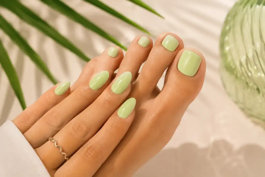 Manicura y pedicura verde pistacho coordinadas para verano 2026 Manicura y pedicura coordinadas en color verde pistacho con acabado brillante, tendencia de verano 2026.