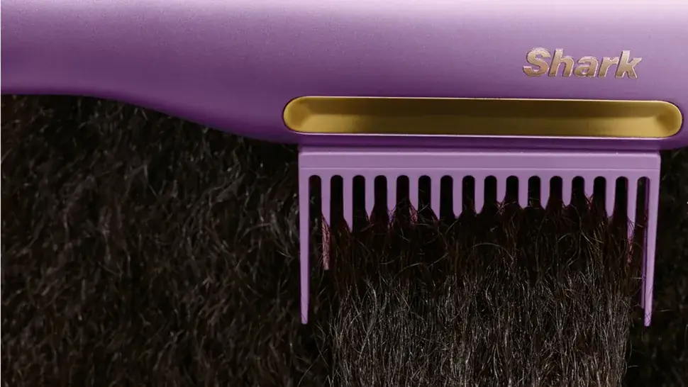 Detalle del peine intercambiable integrado en la herramienta Shark Wet-to-Dry mientras trabaja sobre un cabello rizado y denso.