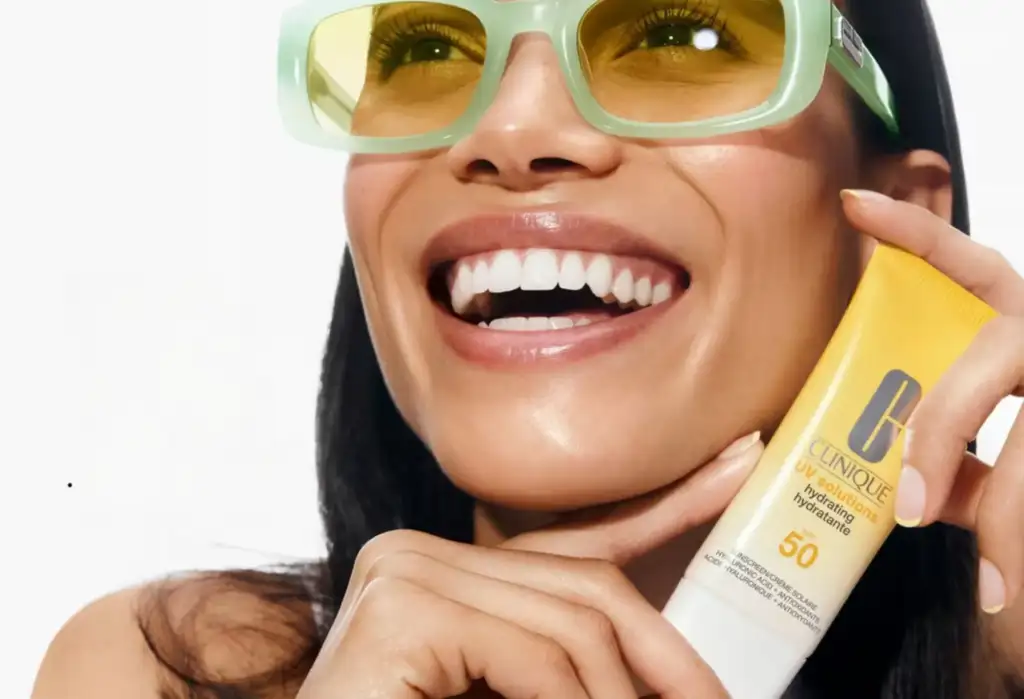 Mujer sosteniendo Clinique UV Solutions Hydrating SPF 50, protector solar facial hidratante