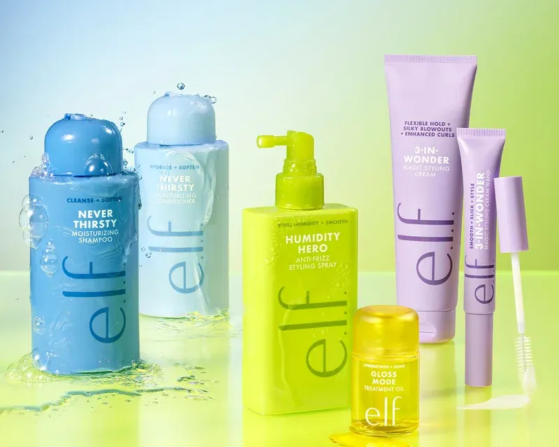 Nueva colección de cuidado capilar de e.l.f. Hair Productos de la línea capilar de e.l.f. Hair con champú, acondicionador, spray antihumedad, crema de peinado, aceite capilar y máscara para cejas sobre un fondo de colores degradados.