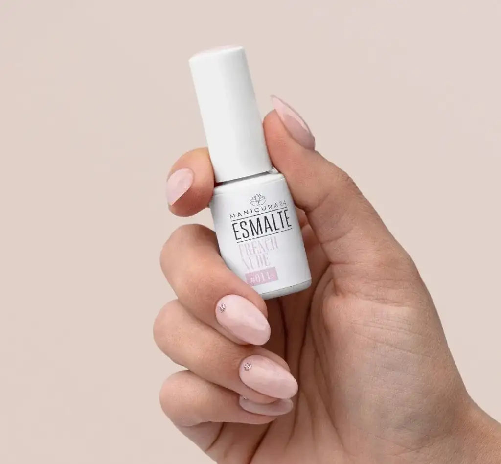 Esmalte French Nude de Manicura24 en mano con manicura natural Mano con manicura nude sosteniendo un esmalte French Nude de Manicura24, ideal para manicuras naturales y elegantes.