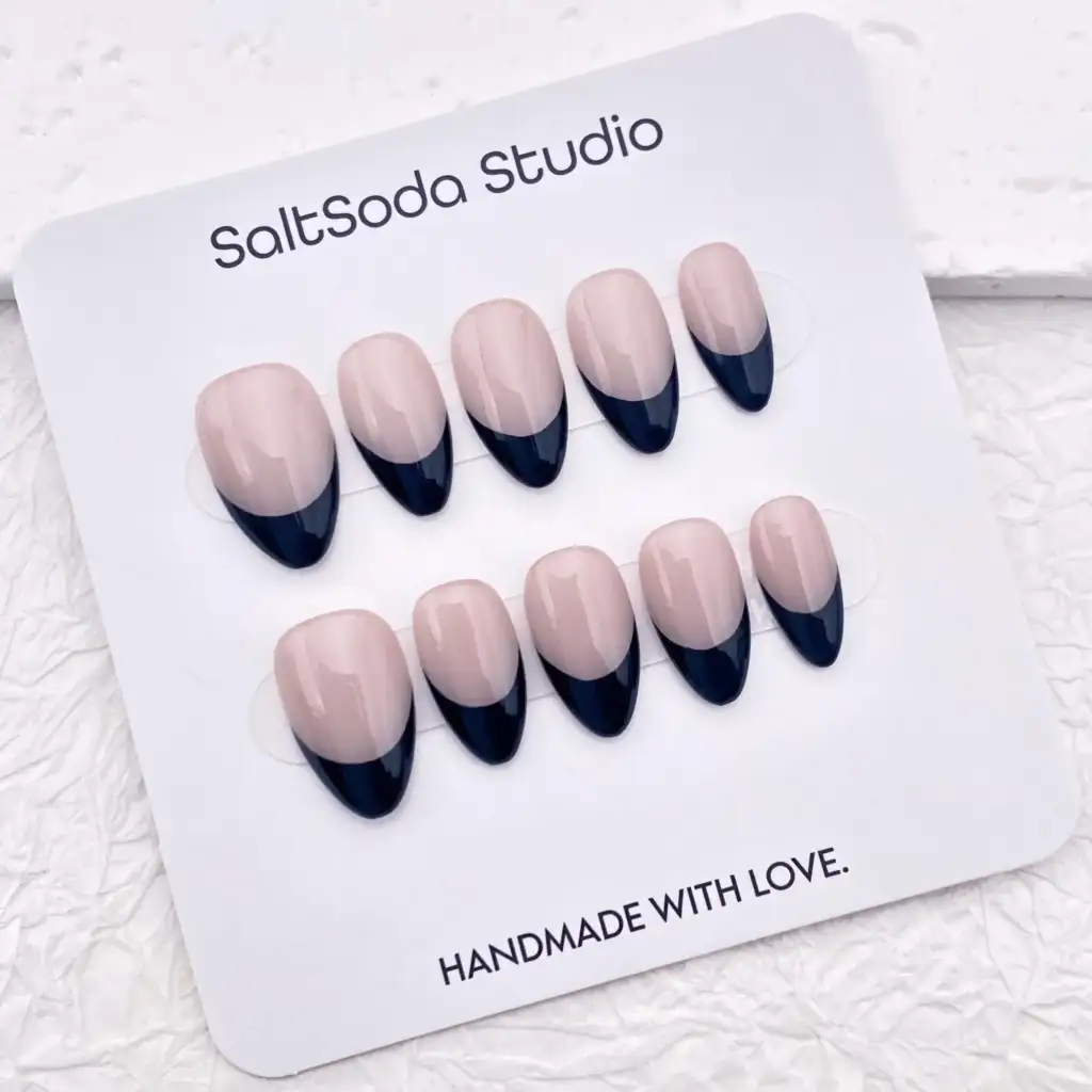 Set de uñas press-on nude con puntas negras estilo manicura francesa