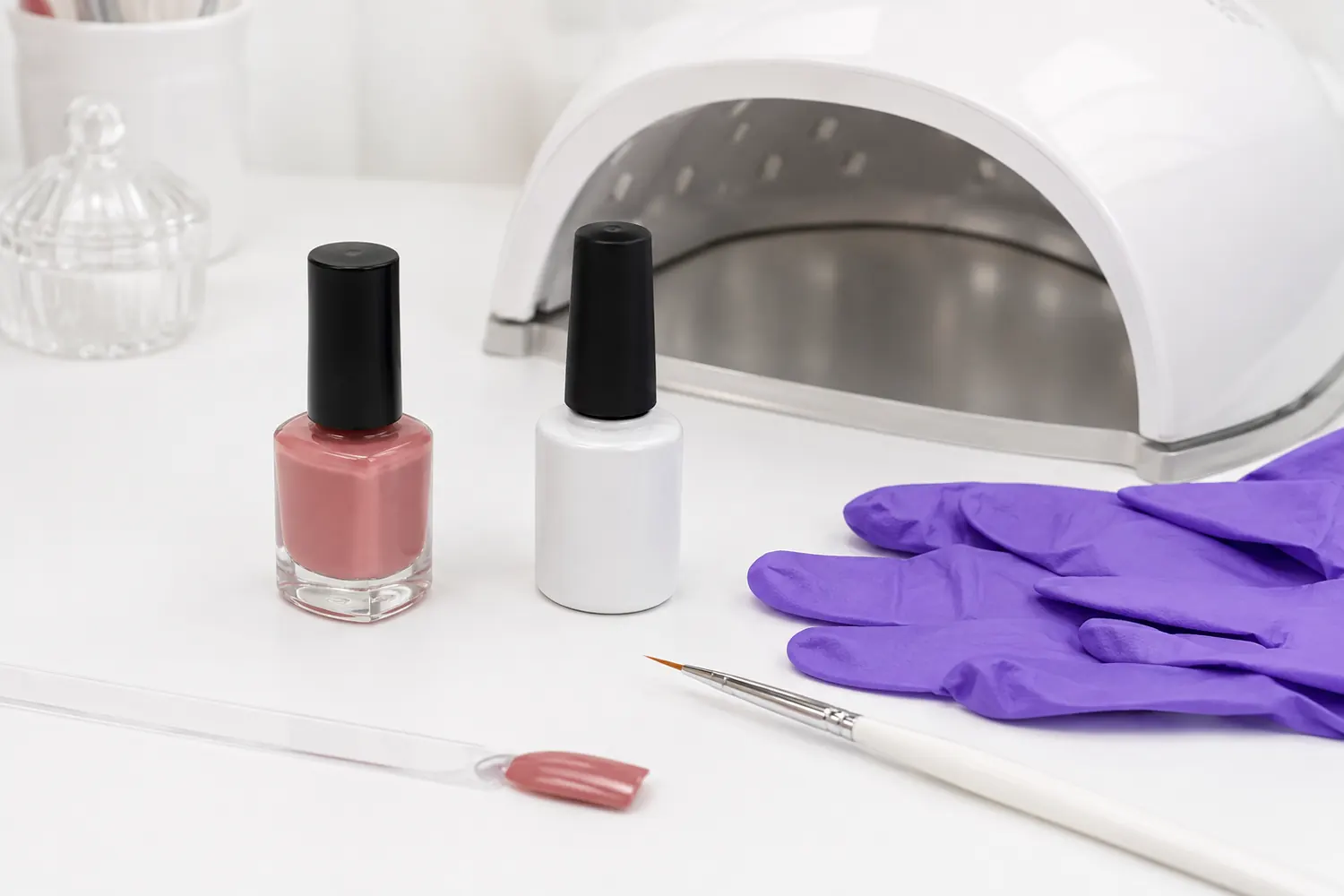 Frascos genéricos de esmalte junto a una lámpara y guantes de manicura
