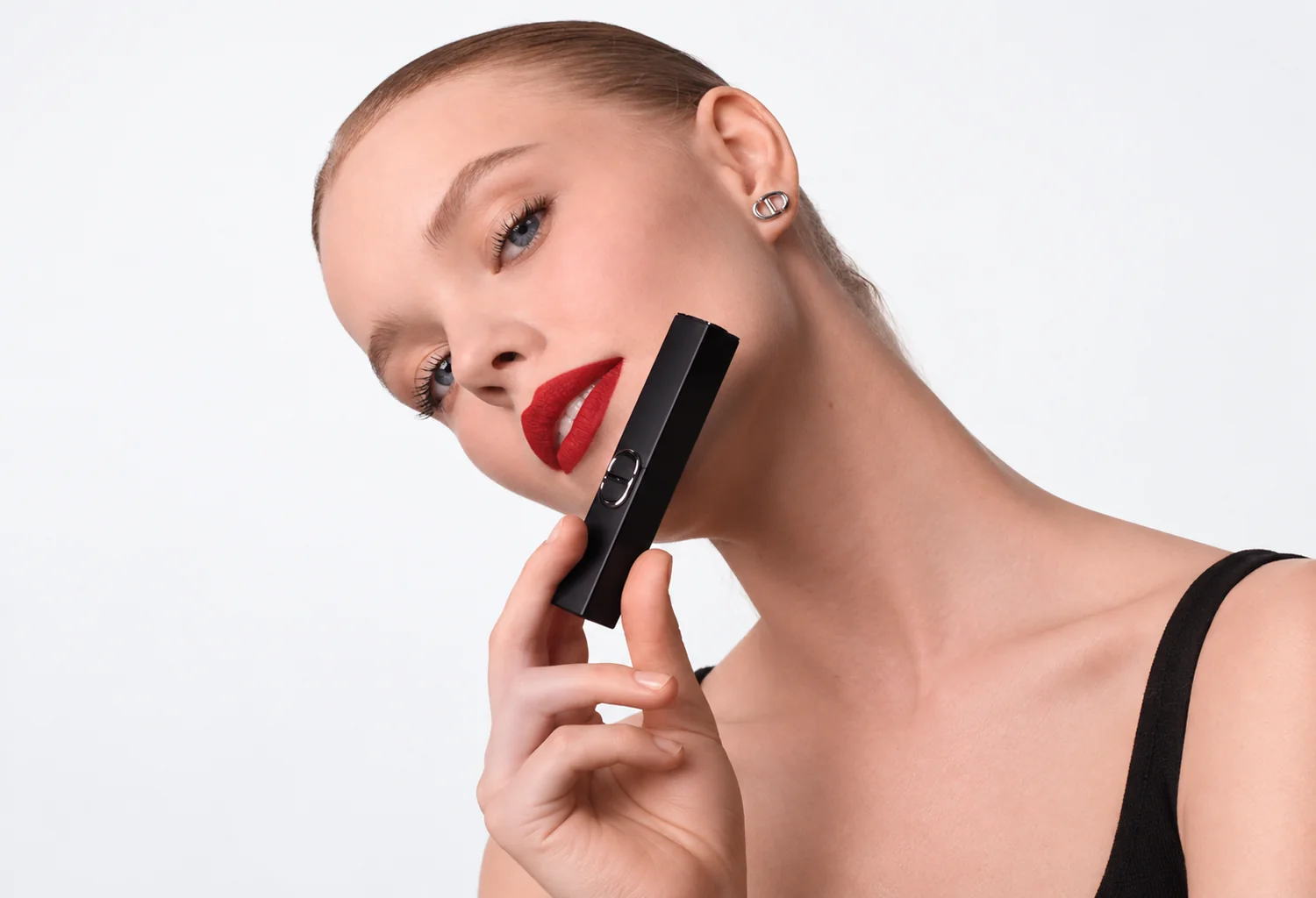 Modelo con labios rojos junto a la barra negra de Rouge Dior On Stage