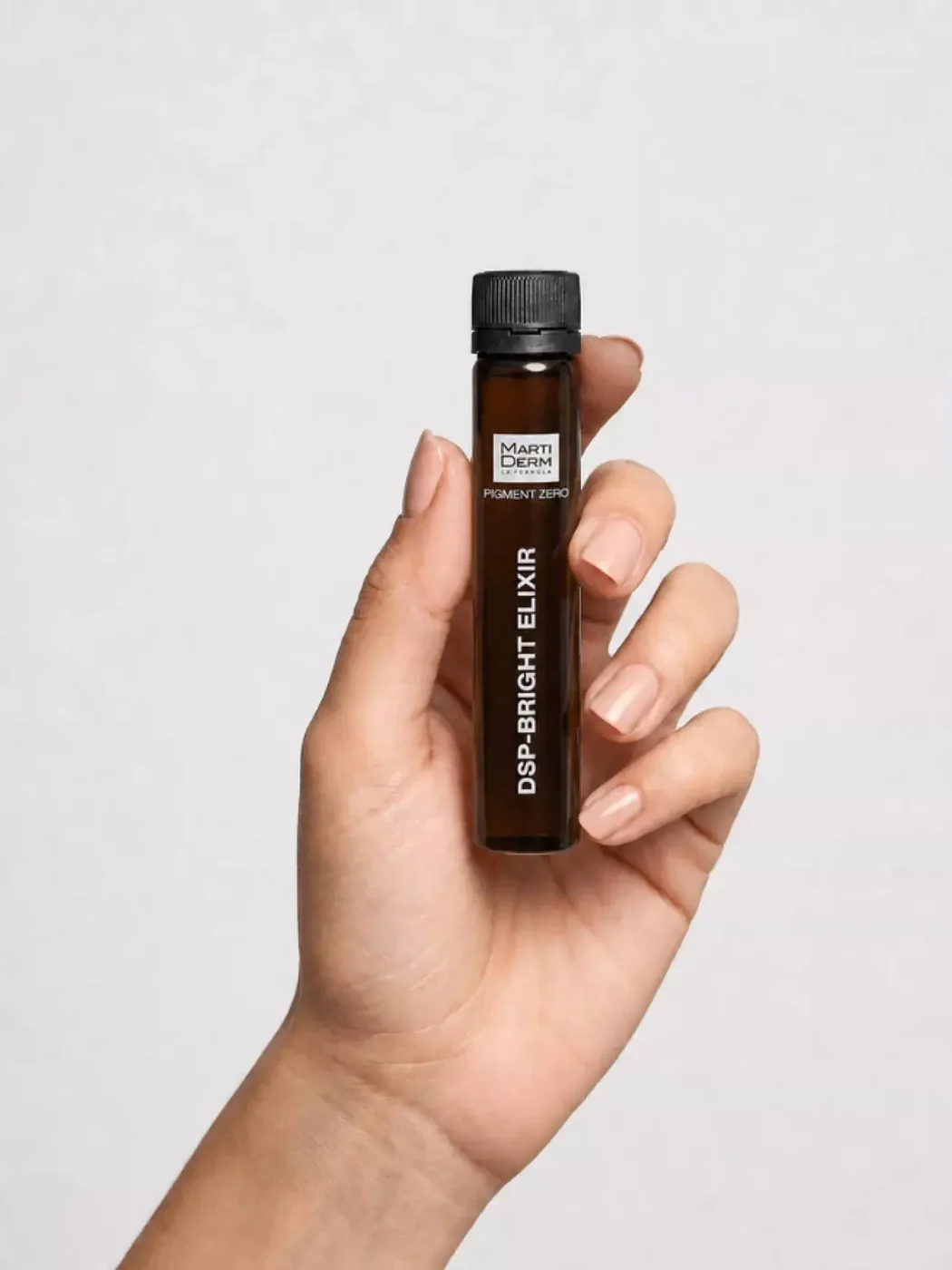 Mano sujetando un vial de DSP-Bright Elixir con la etiqueta visible