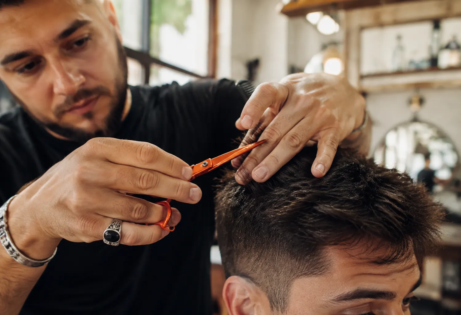 Profesional realizando un corte de precisión con tijeras naranjas en un salón