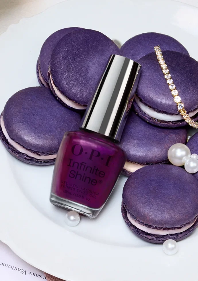 Frasco violeta de OPI Infinite Shine entre macarons