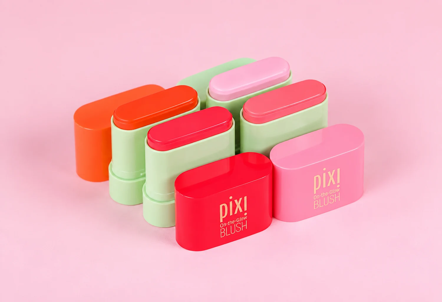 Cuatro coloretes Pixi On-the-Glow Blush Petites abiertos sobre fondo rosa
