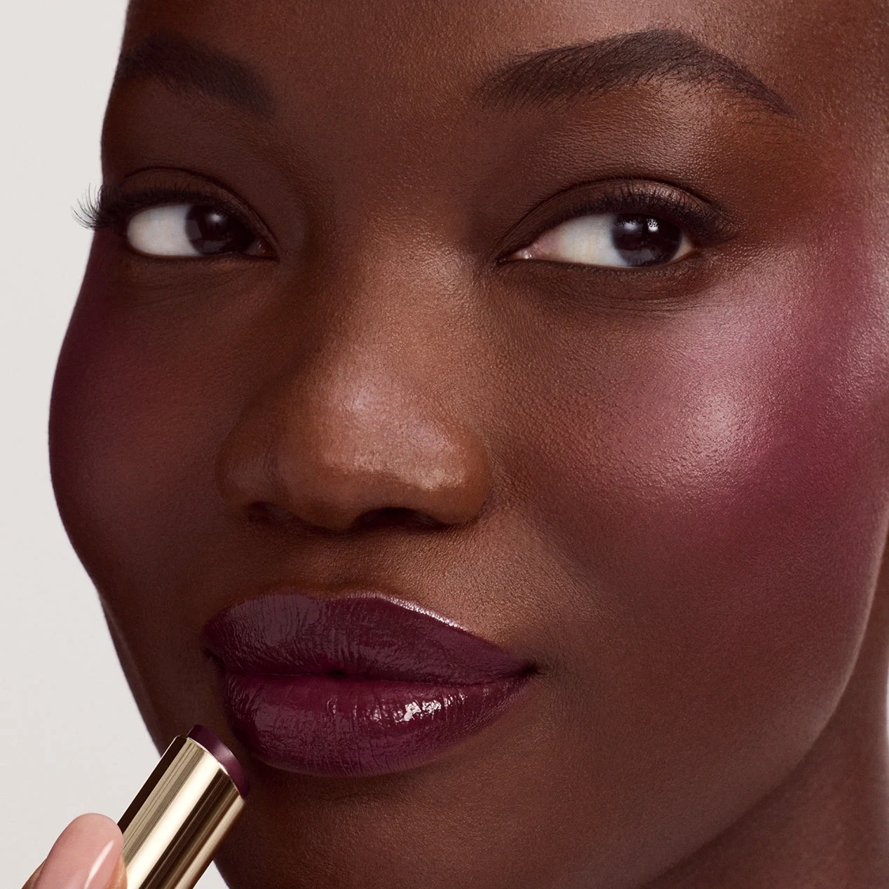 Modelo aplicando la barra labial de Rare Beauty