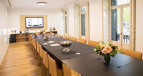 Sala institucional de Stanpa con una mesa larga y pantalla al fondo