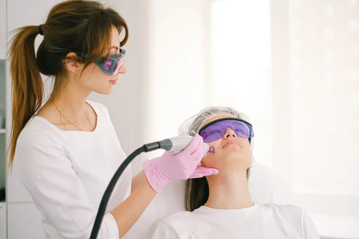 Profesional aplicando tecnología láser facial en un centro de estética