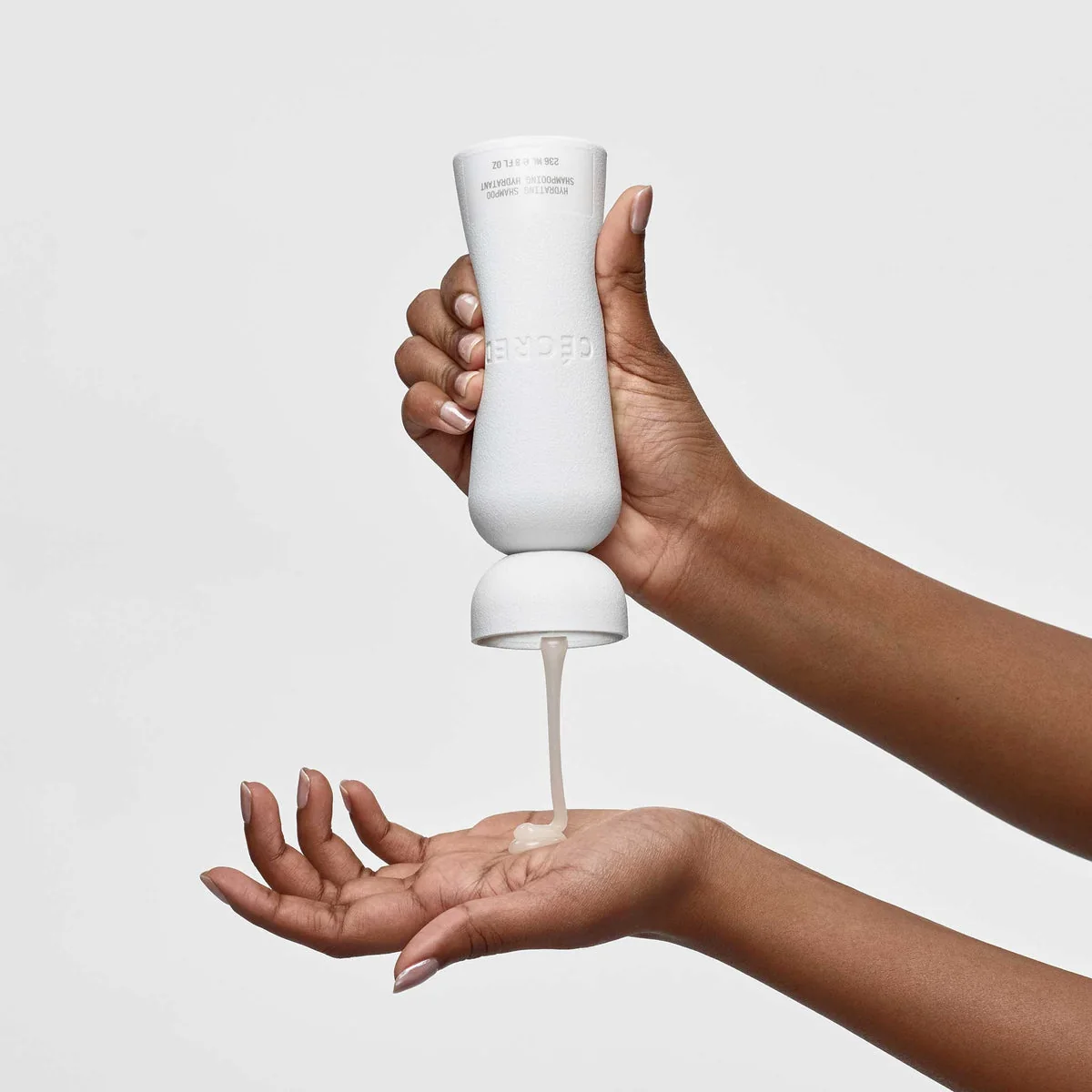 Manos dispensando el champú Hydrating Shampoo de Cécred