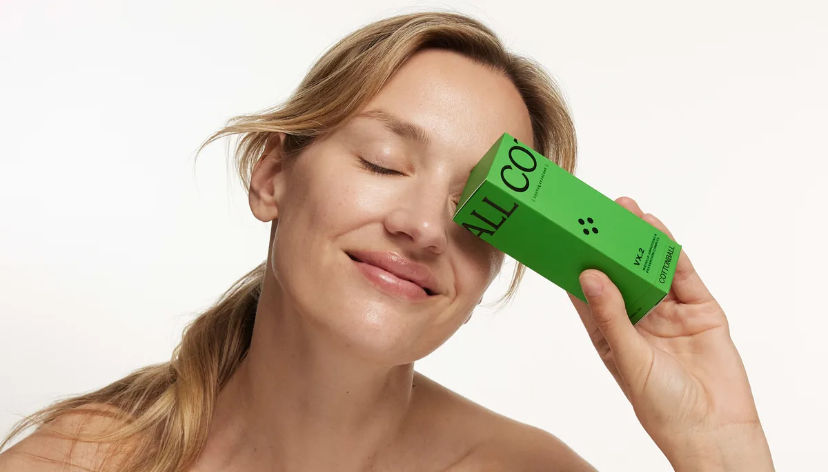 Mujer sosteniendo una caja verde Cottonball