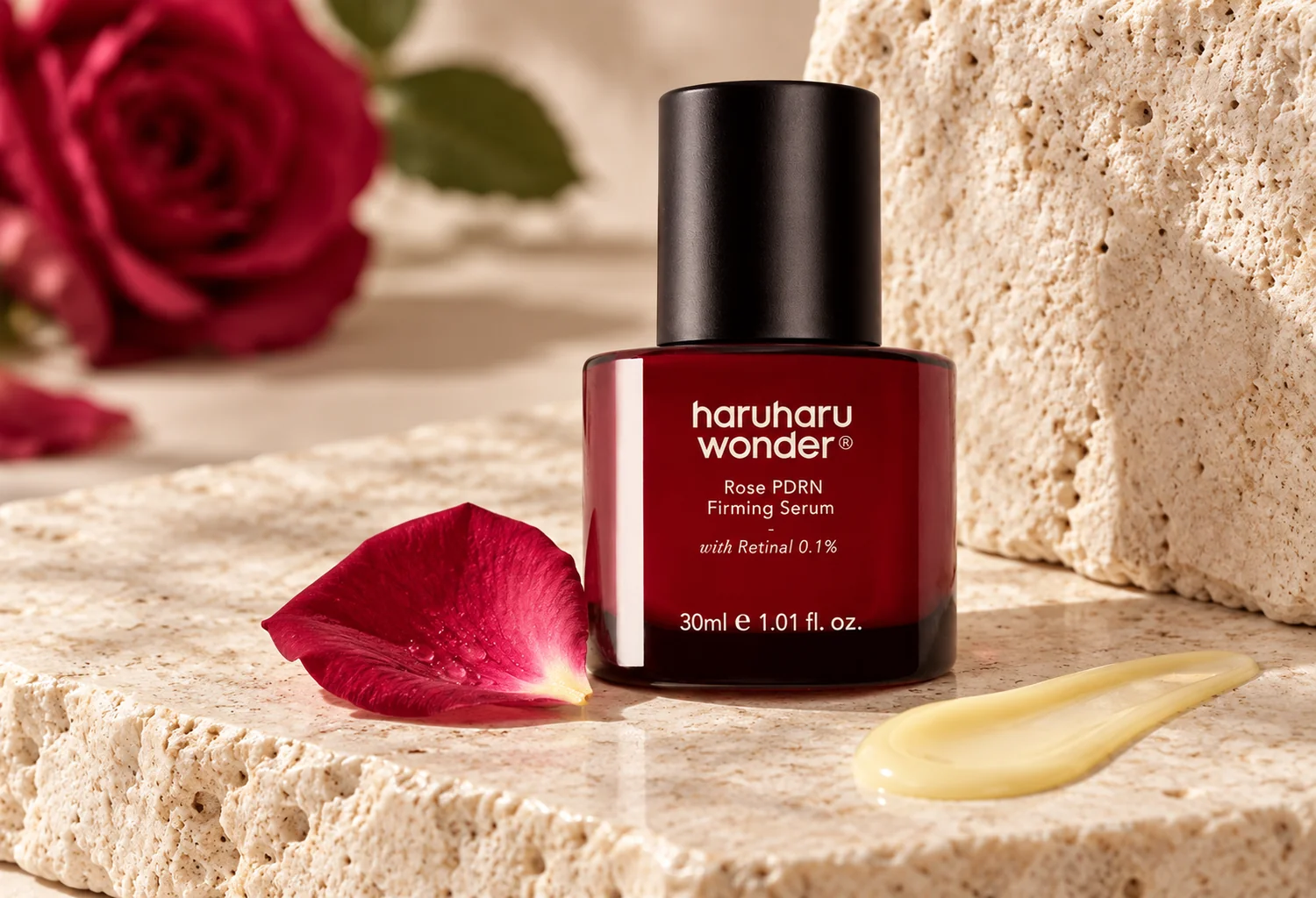Frasco de Rose PDRN Firming Serum junto a una rosa y textura cosmética