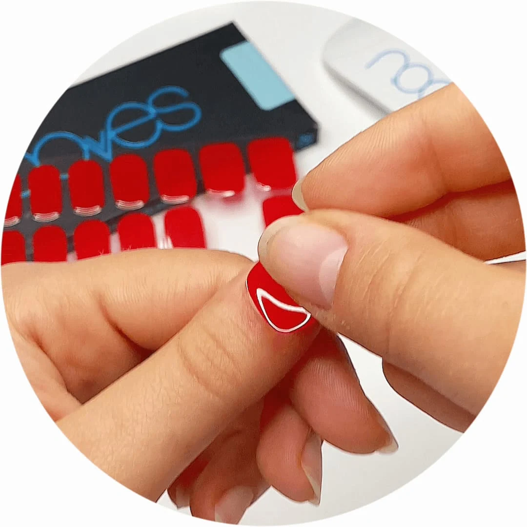 Mano colocando una lámina roja de gel semicurado en una uña
