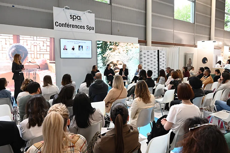 Ponentes y público en una conferencia del espacio spa