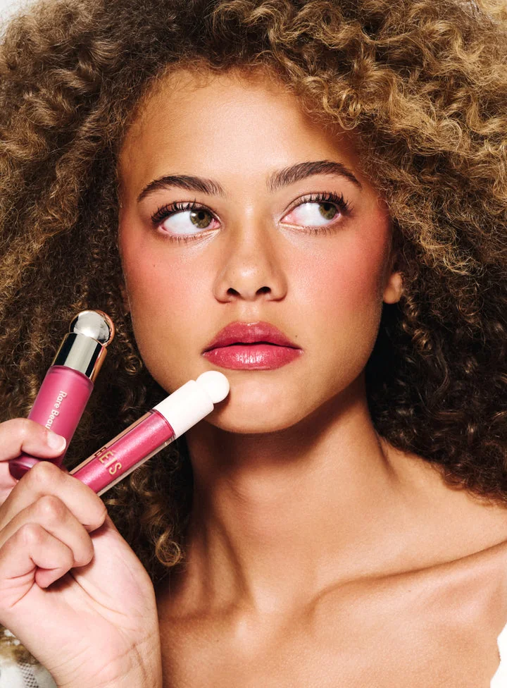 Modelo con el colorete y gloss Limitless de Rare Beauty x BÉIS