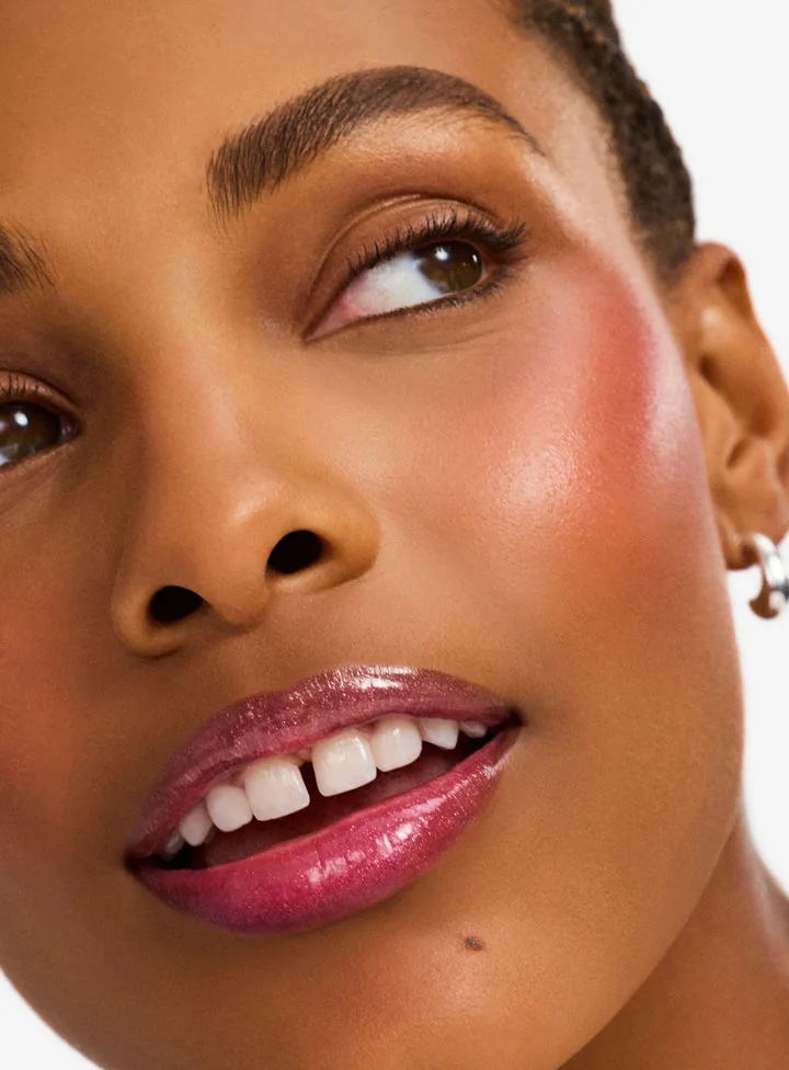 Detalle del brillo de labios y colorete Limitless sobre una modelo