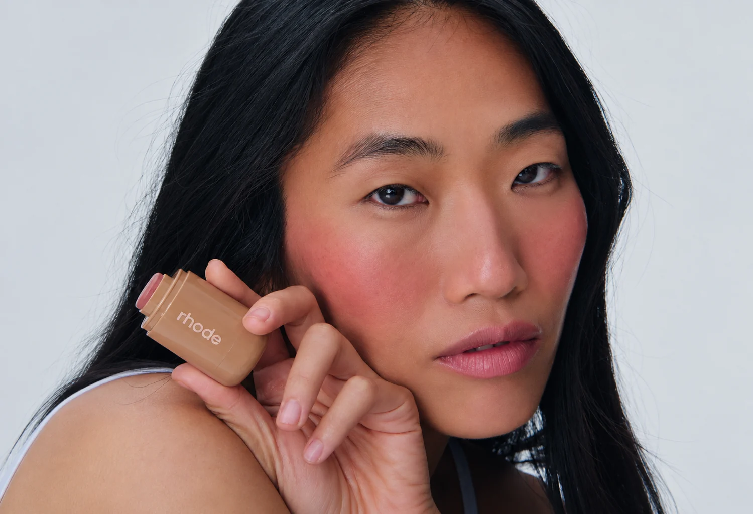 Modelo con el colorete Pocket Blush de Rhode junto al rostro