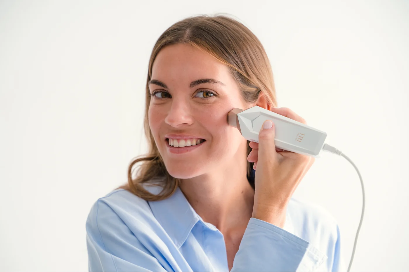 Modelo muestra la aplicación facial de TriPollar Aura en una fotografía oficial de Skinvity